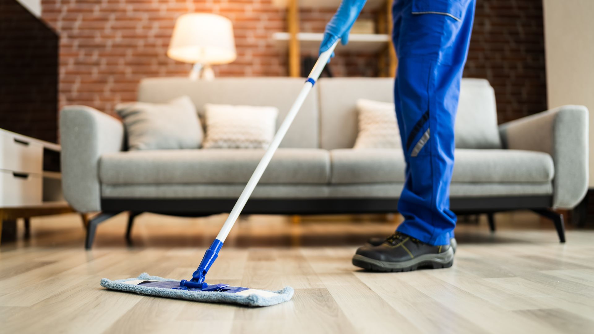 A man with a mop on a hard wood floor